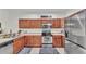 Stylish kitchen with stainless steel appliances, wood cabinets, and tile flooring at 6365 Torrington Cir, Lakeland, FL 33811