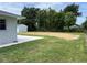 Spacious backyard featuring grass, a white storage shed, and a chain link fence at 6507 Shadowbrook Run, Lakeland, FL 33813