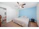 Bedroom features a blue accent wall, ceiling fan, neutral carpet, and side tables at 6507 Shadowbrook Run, Lakeland, FL 33813