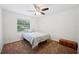 Bedroom with a cozy bed with patterned bedding, window, ceiling fan, and a vintage chest at 6507 Shadowbrook Run, Lakeland, FL 33813