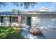 Home's inviting entrance features a brick facade, neatly landscaped walkway, and an American flag at 6507 Shadowbrook Run, Lakeland, FL 33813