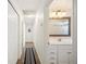 Hallway leads to a full bathroom with vanity, framed mirror and shower with blue curtain at 6507 Shadowbrook Run, Lakeland, FL 33813