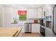 Well-lit kitchen featuring stainless steel appliances, white cabinetry, and modern fixtures at 6507 Shadowbrook Run, Lakeland, FL 33813