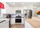 Bright and modern kitchen features stainless steel appliances, white cabinets, and a butcher block countertop at 6507 Shadowbrook Run, Lakeland, FL 33813