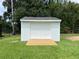 New backyard shed with a pristine exterior and wooden ramp for easy access at 6507 Shadowbrook Run, Lakeland, FL 33813