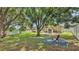 Expansive backyard with mature trees, lush greenery, and play equipment at 6757 High Grove Dr, Lakeland, FL 33813