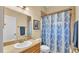 Cozy bathroom featuring an oak vanity, a mirror, and shower and bathtub combo with shower curtain at 6757 High Grove Dr, Lakeland, FL 33813