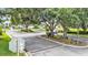 Community entrance with black metal gates, mature trees, and manicured landscaping at 6757 High Grove Dr, Lakeland, FL 33813