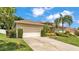 Exterior of home features a well-manicured lawn, trimmed hedges, and a two-car garage at 6757 High Grove Dr, Lakeland, FL 33813