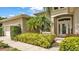 Inviting front entrance featuring a light exterior, lush landscaping, and a welcoming front door at 6757 High Grove Dr, Lakeland, FL 33813