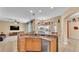 Kitchen with counter seating, stainless steel dishwasher, and connection to living area at 6757 High Grove Dr, Lakeland, FL 33813
