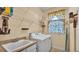 Bright laundry room features a utility sink, washer, dryer, and ample shelving for organized storage at 6757 High Grove Dr, Lakeland, FL 33813