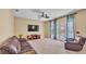 Spacious living room features a comfortable leather sofa, ceiling fan, and sliding doors to the outdoor area at 6757 High Grove Dr, Lakeland, FL 33813