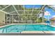 Sparkling screened-in pool surrounded by lush landscaping and clear blue skies at 6757 High Grove Dr, Lakeland, FL 33813
