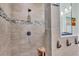 Modern shower featuring tile walls, a rainfall showerhead, and a convenient built-in bench at 6757 High Grove Dr, Lakeland, FL 33813