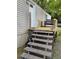 Exterior shot of a home's wooden deck with weathered stairs leading up to a partially furnished seating area at 6915 Dove Meadow Trl, Lakeland, FL 33810