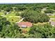 Aerial view of a home with a brown roof, surrounded by lush greenery and mature trees at 6920 Newman E Cir, Lakeland, FL 33811