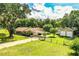 An aerial view of a home with a big lawn, carport, detached garage, and fenced-in yard at 6920 Newman E Cir, Lakeland, FL 33811