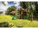 A wooden backyard playset with slide and swings provides entertainment for children at 6920 Newman E Cir, Lakeland, FL 33811