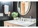 Bathroom features modern lighting with white marble vanity and black accent wall at 6920 Newman E Cir, Lakeland, FL 33811