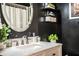 Modern bathroom features sleek black walls, a white marble vanity, and a round LED mirror at 6920 Newman E Cir, Lakeland, FL 33811