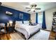 Bedroom featuring a blue accent wall, hardwood floors, ceiling fan, and cozy rug, enhancing comfort and style at 6920 Newman E Cir, Lakeland, FL 33811