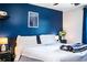 Bedroom showcasing a stylish blue accent wall, ceiling fan, and comfortable layout, blending aesthetics with functionality at 6920 Newman E Cir, Lakeland, FL 33811