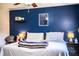 Bedroom showcasing a stylish blue accent wall, ceiling fan, and comfortable layout, blending aesthetics with functionality at 6920 Newman E Cir, Lakeland, FL 33811