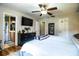 Bright primary bedroom featuring hardwood floors, ceiling fan, and a view into the en-suite bathroom at 6920 Newman E Cir, Lakeland, FL 33811