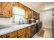 Kitchen with wood cabinets, tile flooring, stainless steel appliances, and large window at 6920 Newman E Cir, Lakeland, FL 33811