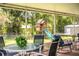 View of the patio table set with chairs and the playhouse in the backyard at 6920 Newman E Cir, Lakeland, FL 33811