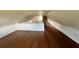 Spacious finished attic featuring beautiful wood floors, white walls, and a brick chimney at 701 1St Ne St, Fort Meade, FL 33841