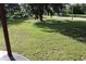 Expansive backyard features lush green grass, mature trees, and is ideal for outdoor activities and relaxation at 701 1St Ne St, Fort Meade, FL 33841