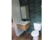 Modern bathroom featuring a floating sink and blue-green tile accent wall at 701 1St Ne St, Fort Meade, FL 33841
