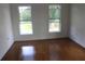 Bright bedroom featuring hardwood floors and two windows offering ample natural light at 701 1St Ne St, Fort Meade, FL 33841