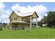 Exterior shot of home with wraparound porch, large columns and metal roof at 701 1St Ne St, Fort Meade, FL 33841