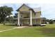 Charming two-story home with a metal roof and large pillars on an expansive green lawn at 701 1St Ne St, Fort Meade, FL 33841