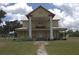 Exterior shot of home with wraparound porch, large columns and metal roof at 701 1St Ne St, Fort Meade, FL 33841