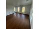 Bright living room features hardwood floors, white walls, and three large windows at 701 1St Ne St, Fort Meade, FL 33841