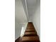 Elegant staircase featuring dark wood steps, white risers, and a minimalist design leading to the upper level at 701 1St Ne St, Fort Meade, FL 33841
