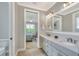 Bathroom with double sinks and an open doorway to the main bedroom at 7770 Lake James Blvd, Lakeland, FL 33810