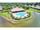 Community pool overlooking lake featuring a covered seating area, lounge chairs, and manicured landscaping at 7770 Lake James Blvd, Lakeland, FL 33810