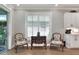 Bright sitting area with comfortable chairs, shuttered window and sliding glass door to a patio at 7770 Lake James Blvd, Lakeland, FL 33810