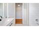 Modern bathroom featuring white subway tile, updated fixtures, and wood flooring in the hallway at 783 E Central Ave, Eagle Lake, FL 33839