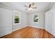Bright, neutral bedroom featuring hardwood floors, two windows, white trim, and two closets at 783 E Central Ave, Eagle Lake, FL 33839