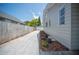 Long driveway leading to a detached garage, bordered by a wooden fence and fresh landscaping at 783 E Central Ave, Eagle Lake, FL 33839