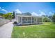 Charming single-story home featuring a screened-in porch, a manicured lawn, and mature trees at 783 E Central Ave, Eagle Lake, FL 33839