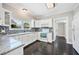 Well-lit kitchen with white cabinets, dark tile floor, granite countertops, and stainless-steel appliances at 783 E Central Ave, Eagle Lake, FL 33839