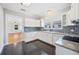 Modern kitchen with white cabinetry, granite countertops, mosaic backsplash, and black tile floors at 783 E Central Ave, Eagle Lake, FL 33839