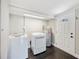 Well-lit laundry room featuring new washer and dryer, a water heater, tile floors, and a door to the backyard at 783 E Central Ave, Eagle Lake, FL 33839
